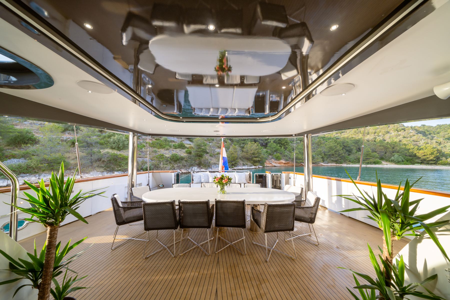 Navilux motor sailing yacht - outdoor, covered lower deck with a big dining table and open air lounge area.