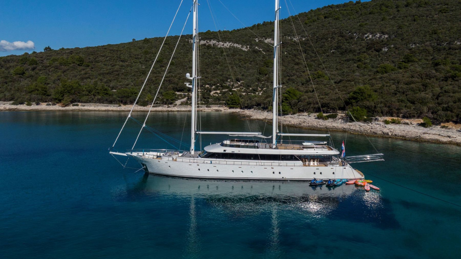 Aurum Sky sailing yacht - anchored with many sea toys tied to it, near Croatia's coastline. Ready for its Croatia sailing.
