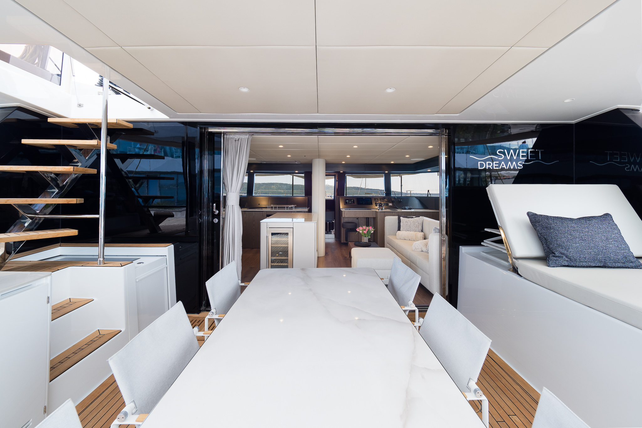 Sweet Dreams luxury yacht stern lower deck outdoor covered dining area with a small lounge area.