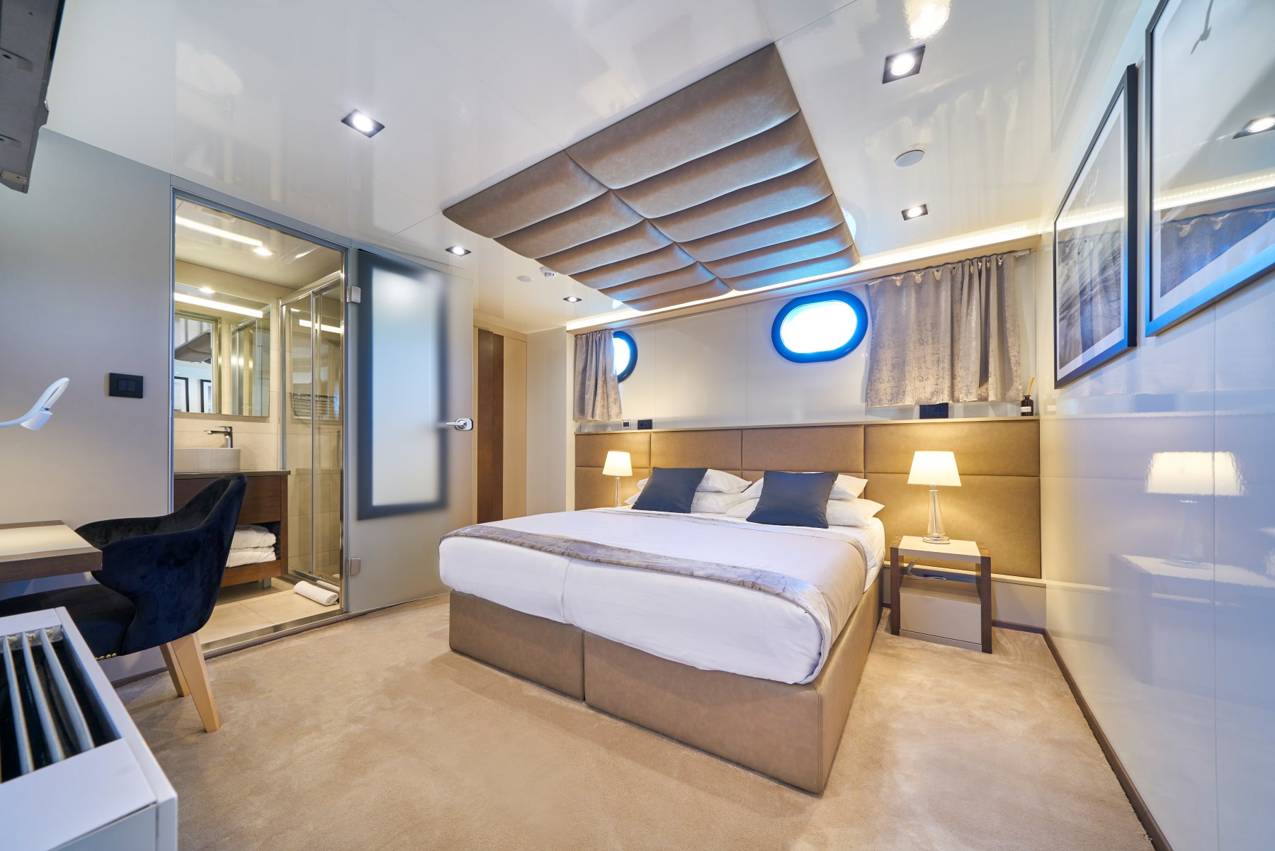 Rara Avis sailing yacht - cabin with a double bed, 2 portholes, dressing table, and an ensuite bathroom.