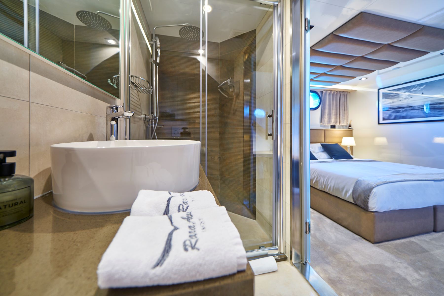 Rara Avis sailing yacht - bathroom and a cabin with a double bed and a porthole.