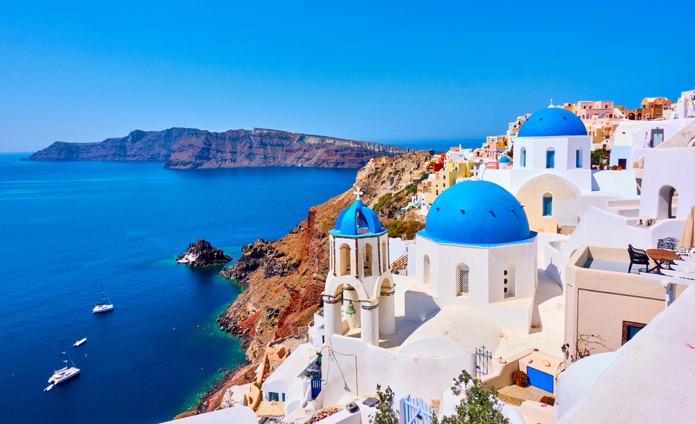 View of Oia town with churches with blue domes in Santorini island in Greece