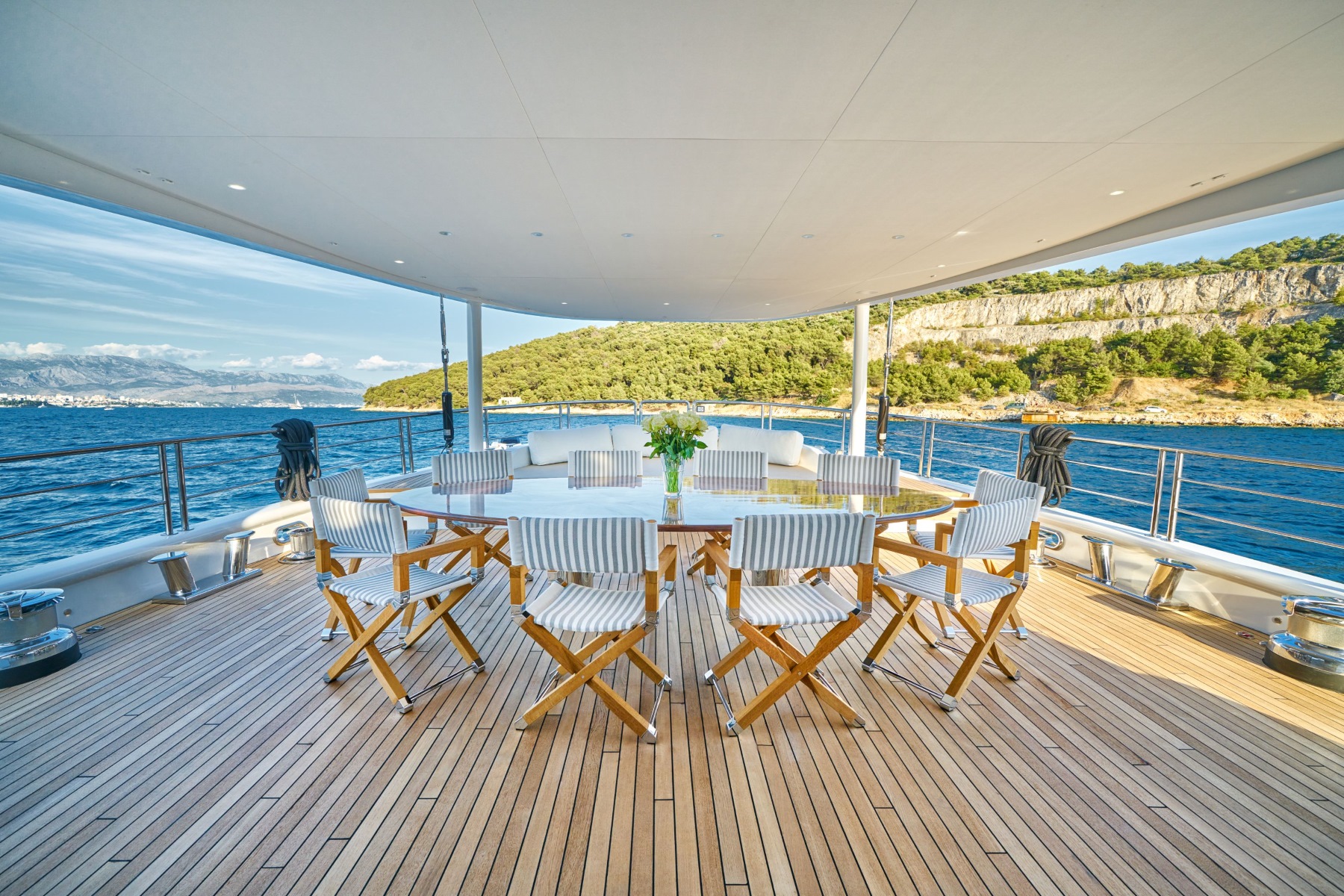 Acapella luxury charter yacht outdoor covered dining area and a lounge area on the lower deck.