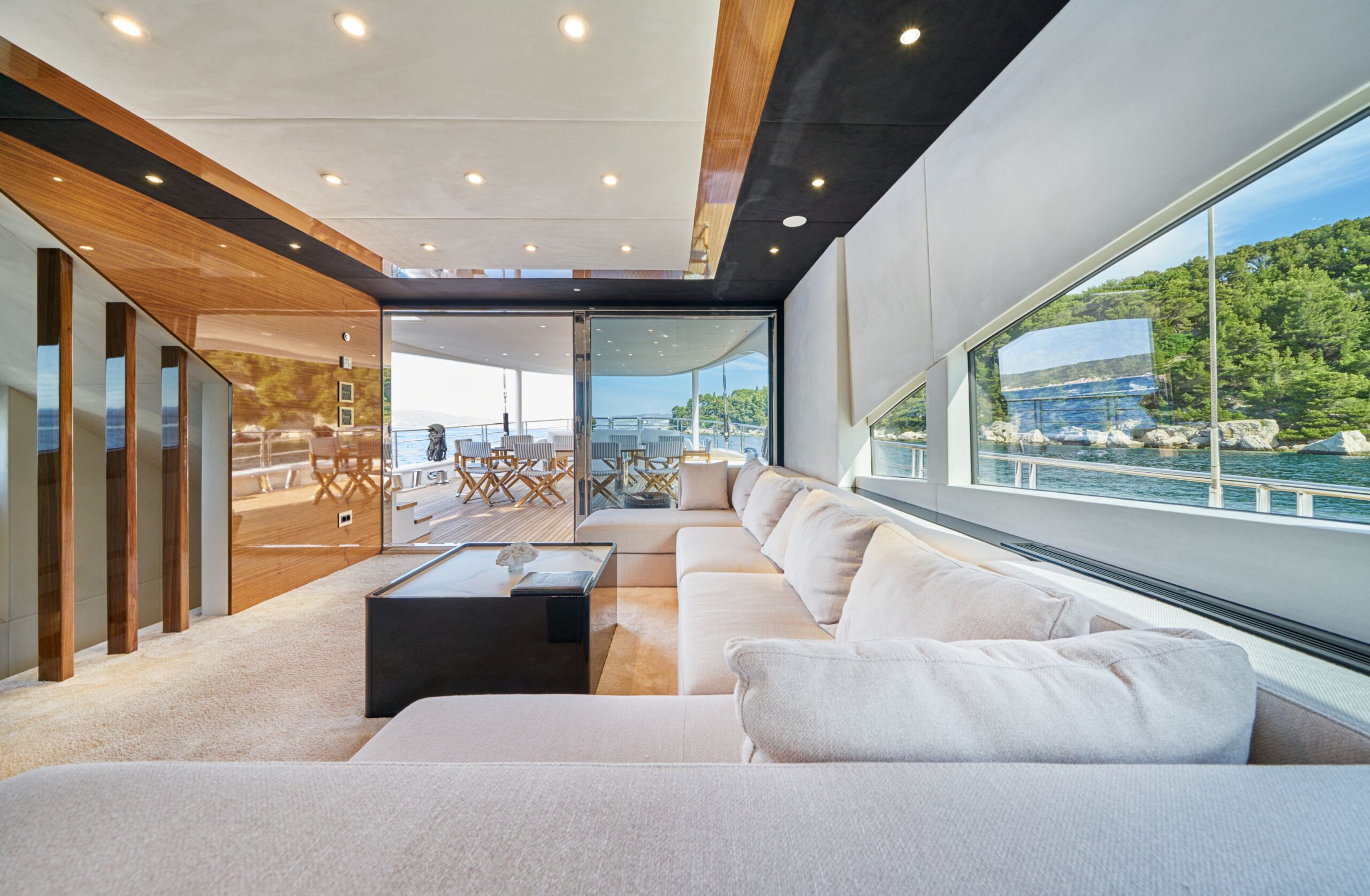 Acapella luxury charter yacht indoor lounge area with large window surfaces.