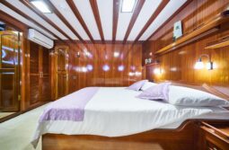 Stella Maris cabin with a double bed, 2 porthole windows and an air conditioner