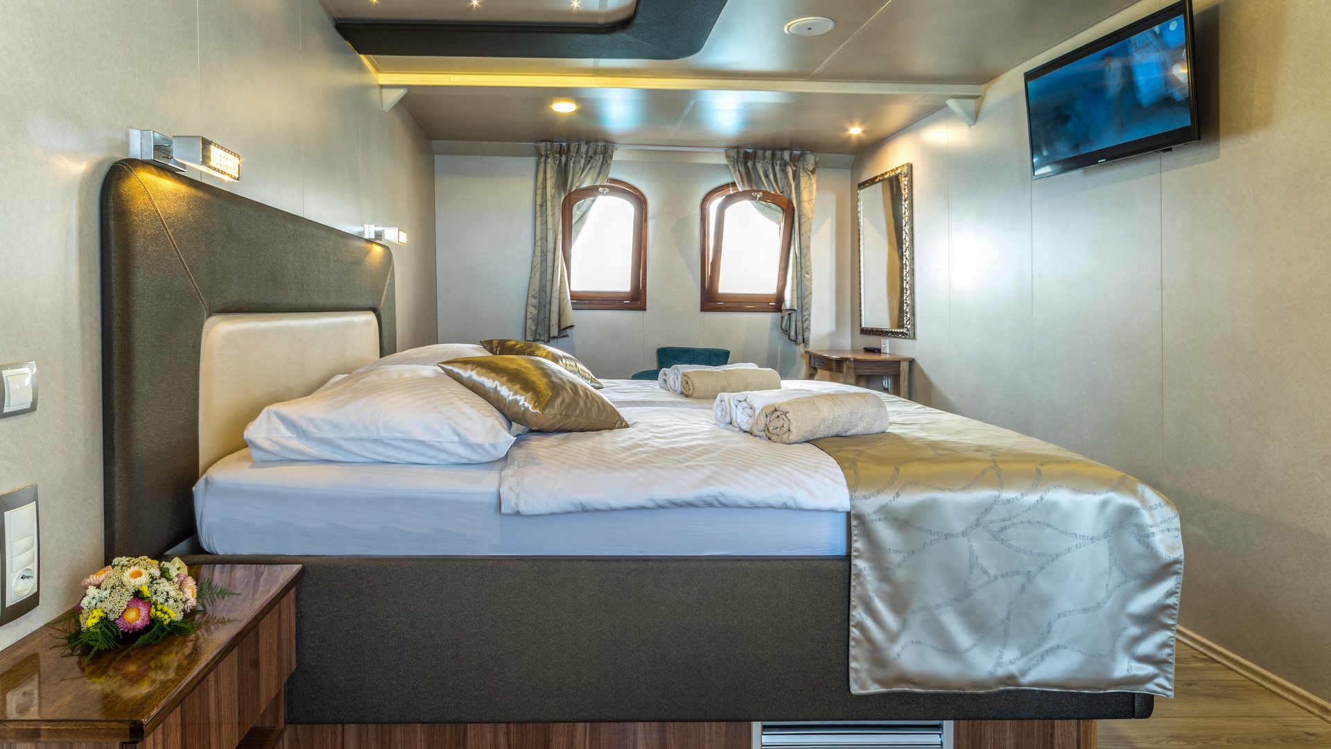 MY Casablanca ensuite cabin with a double bed a 2 windows and a TV