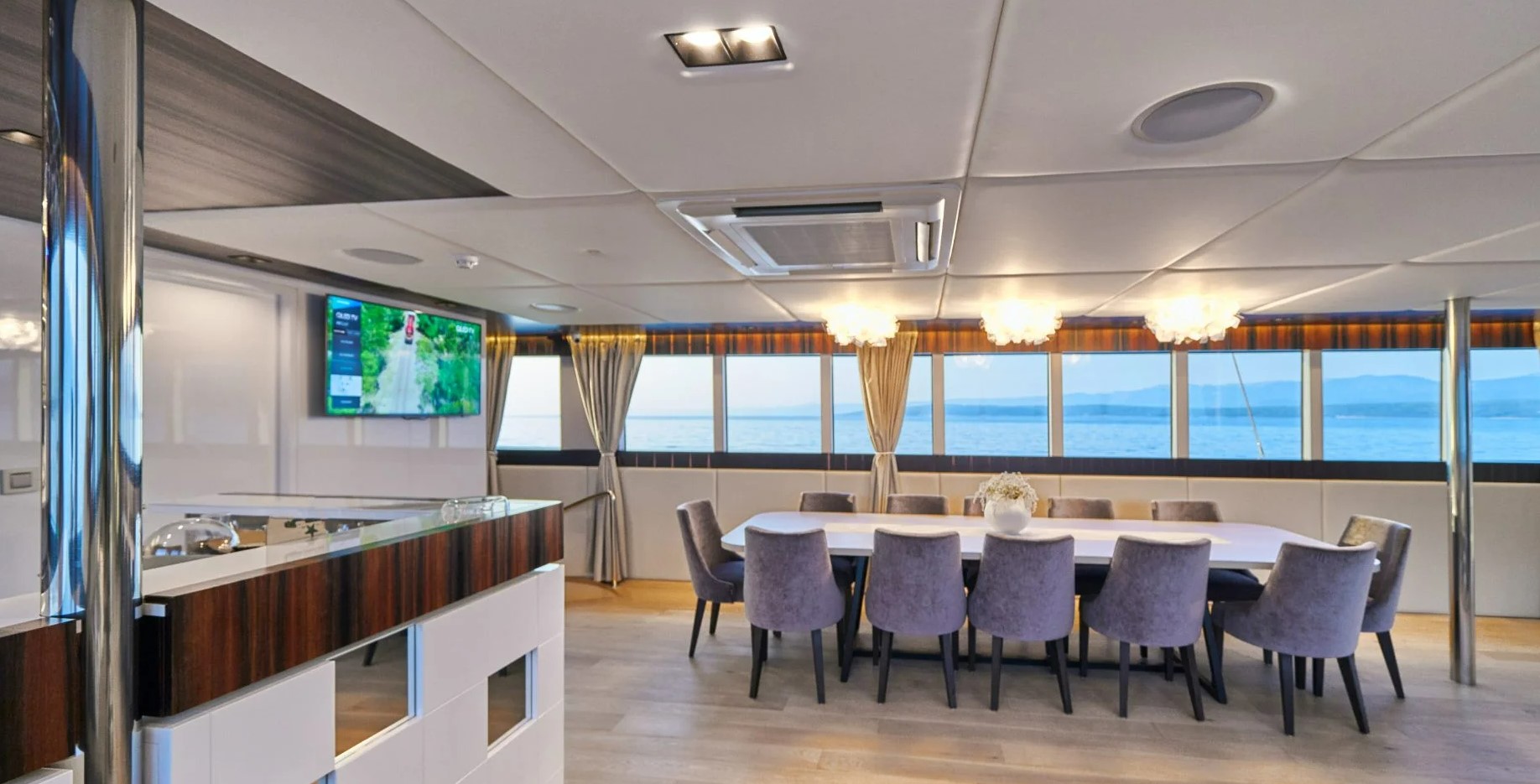 Dalmatino yacht dining area and bar with big windows overlooking the Adriatic Sea in Croatia.