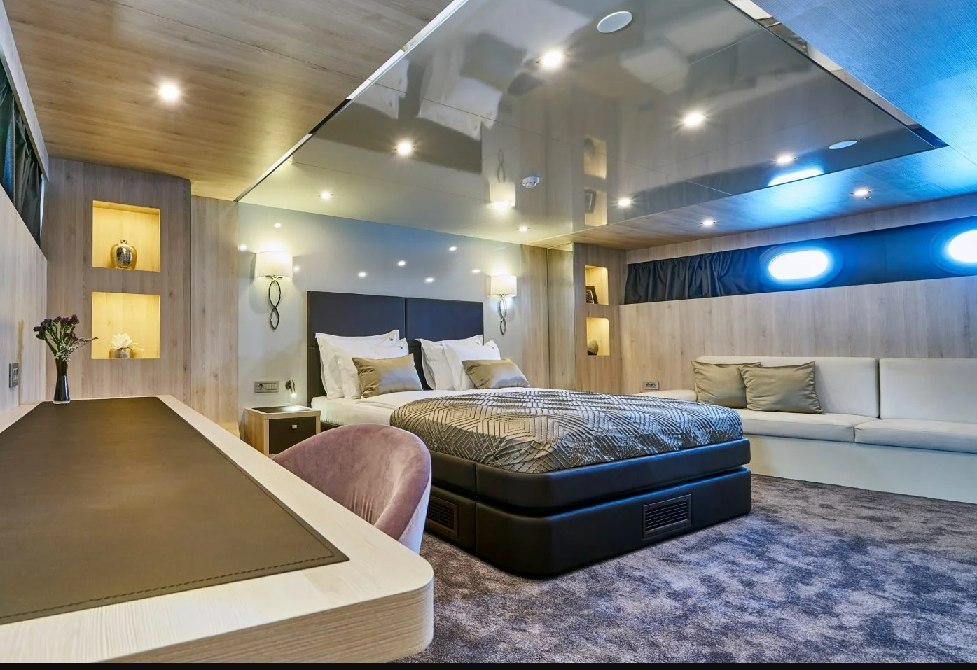 Dalmatino yacht cabin with double bed, big sofa, dresssing table and 2 portholes