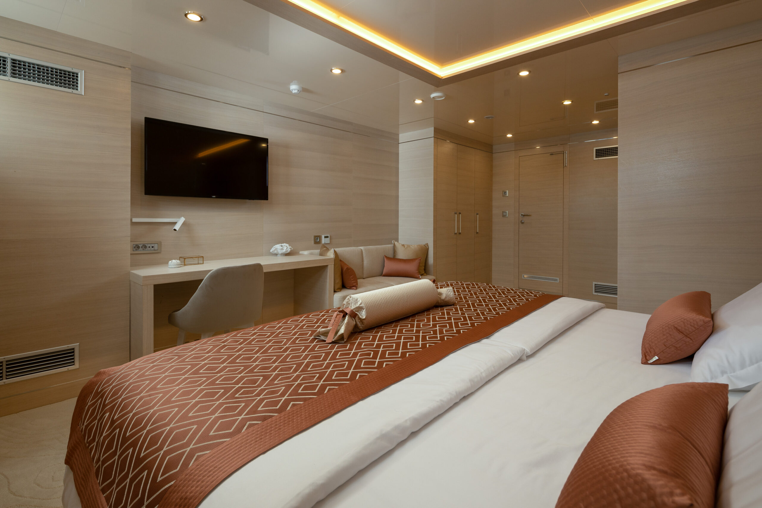 Love Story's luxurious sailing yacht ensuite cabin with double bed, sofa, and a dressing table.