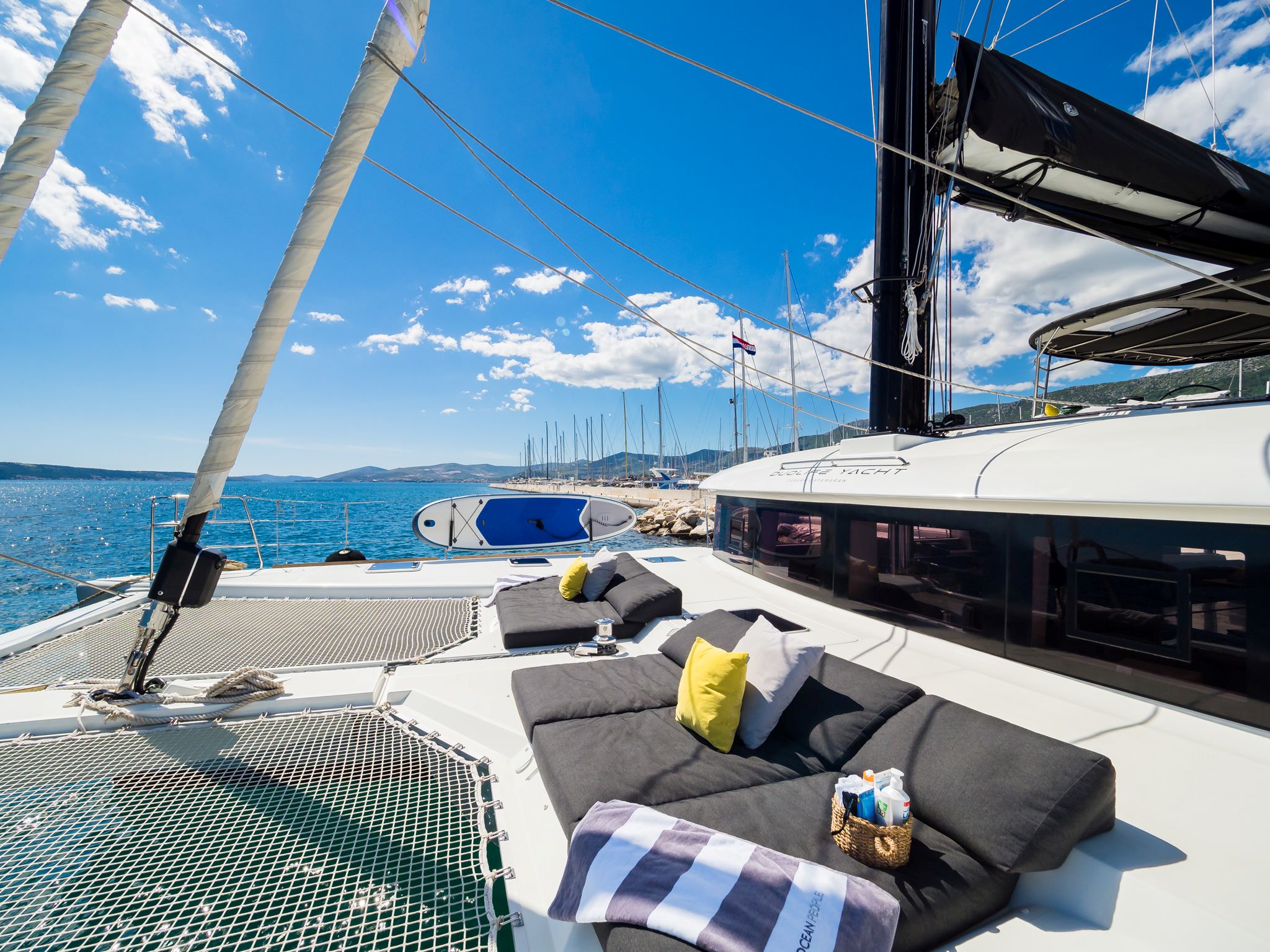 Luxury yacht Duolife catamaran lounge area with nets, and sunbeds on the bow of the yacht, anchored in the Adriatic sea in Croatia