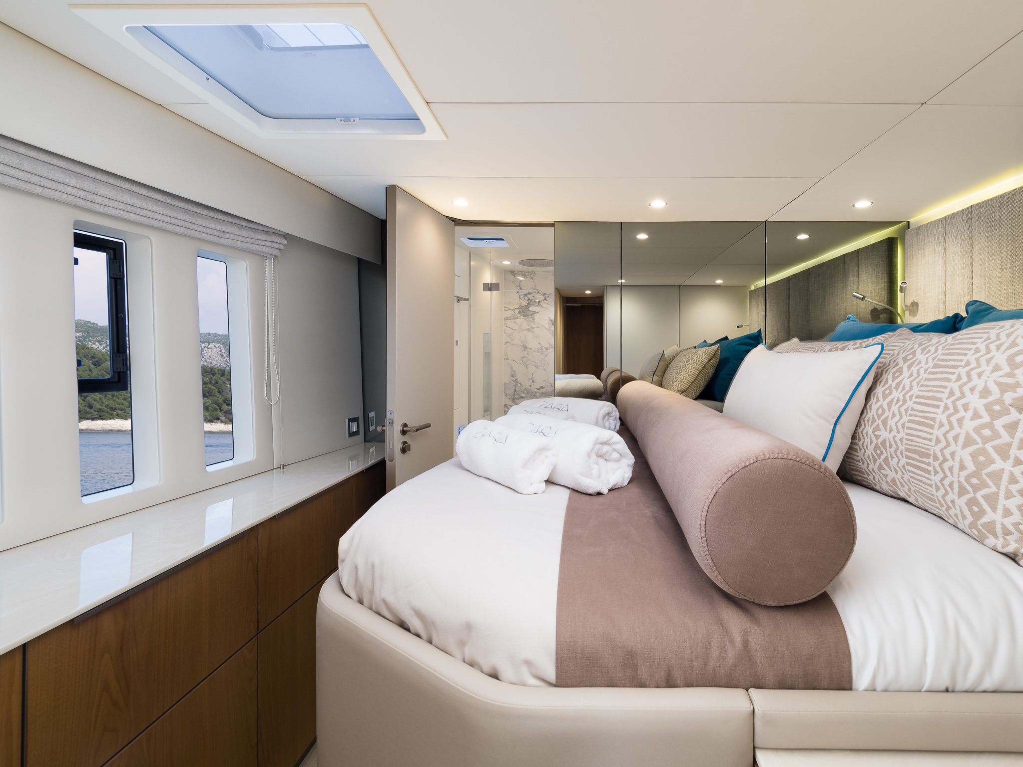 Sunreef 50 ZARA luxury catamaran ensuite cabin with a double bed and several big windows and a roof window with cabin doors opened