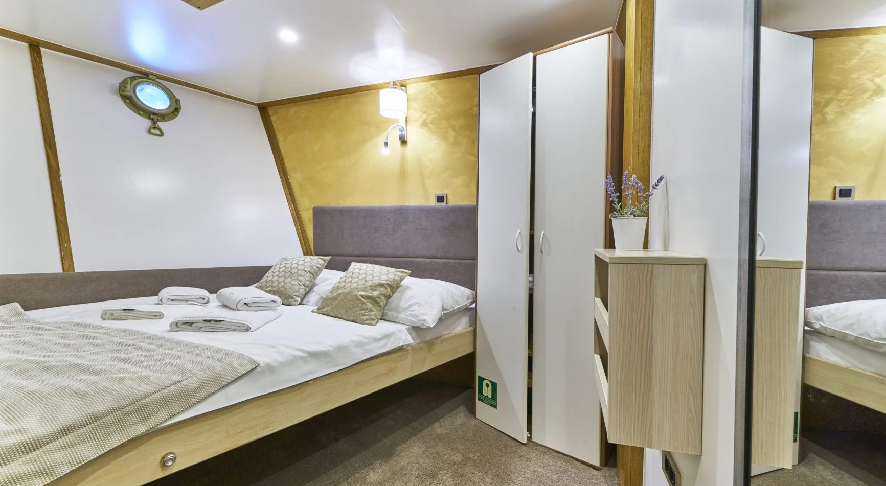 MS ROMANCA yacht cabin with a double bed and a porthole window