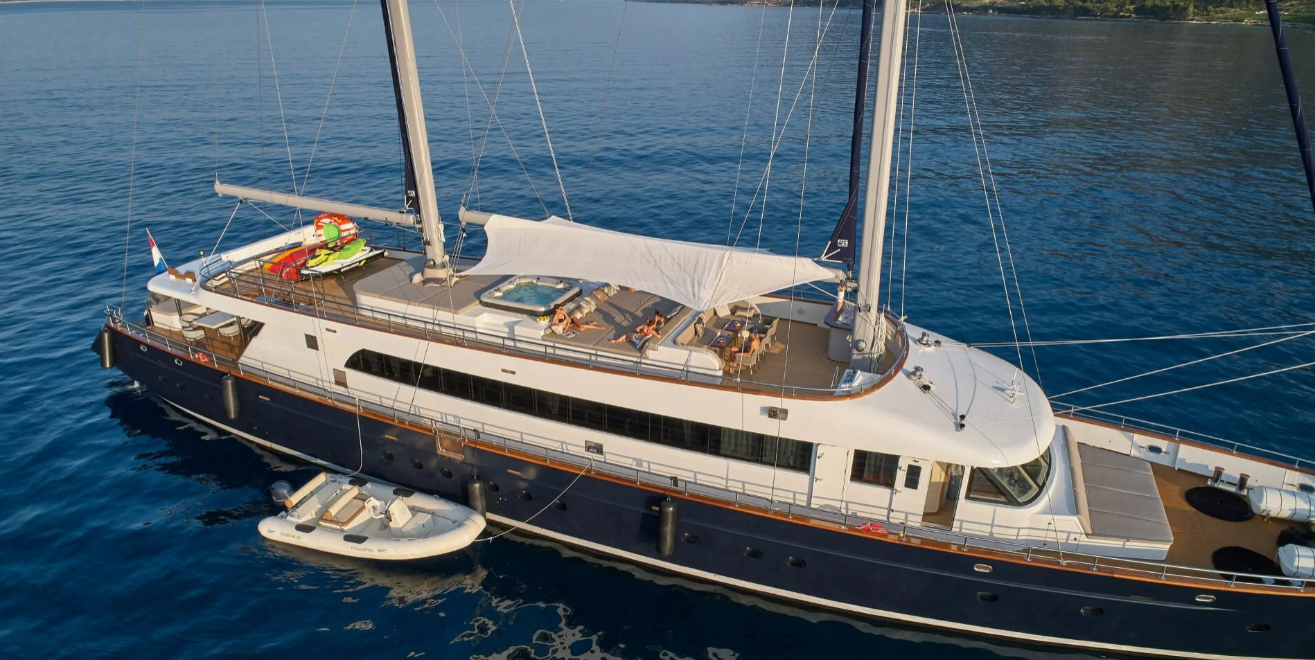 Guests sunbathing on the sun deck of anchored Dalmatino yacht in Adriatic sea in Croatia