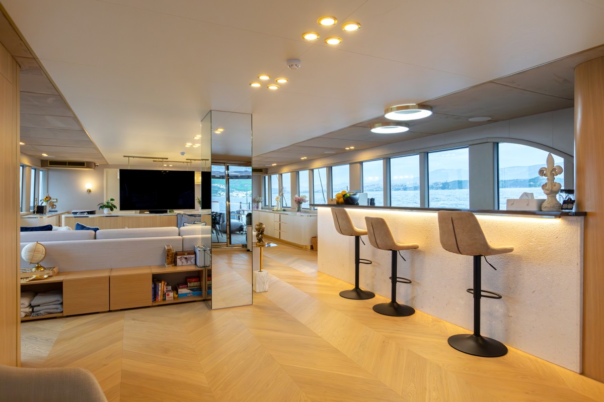 Scorpios sailing yacht's salon with a bar and a lounge area with big windows.